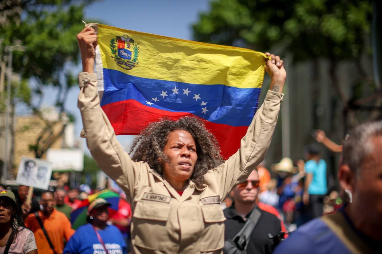 Miliciana Bolivariana de Venezuela sostiene la bandera ante las palabras del presidente Nicolás Maduro